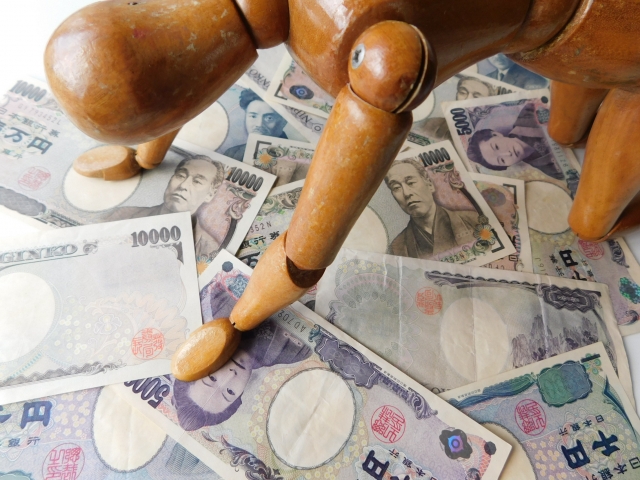 お金の上でうなだれる。狛江市で借金返済の相談は無料でできます