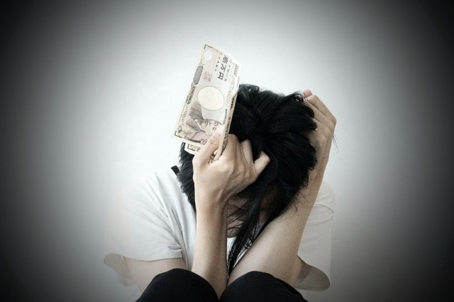 お金を手に頭を抱える。四街道市で債務整理の無料相談が弁護士にできます
